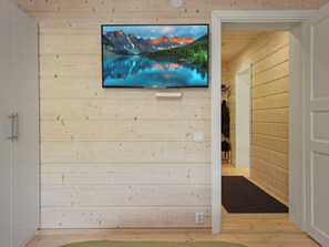 A television mounted on a wooden wall with a mountain landscape. - Villa ruuska by Interhome (Kivijärvi)