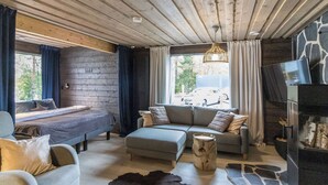 A cozy room with a bed, sofa, and a fireplace.
