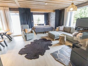 Una sala de estar moderna con un sofá, un sillón y una mesa de comedor.
