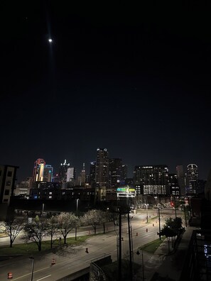 Una vista nocturna del paisaje urbano con edificios iluminados y un cielo despejado.