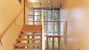 A wooden staircase with a glass door leading to an outdoor area. - Villa sinikka 1 by Interhome (Mikkeli)