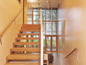 A wooden staircase with a glass door leading to an outdoor area.