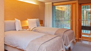 A hotel room with two beds, a balcony, and a view of the outdoors. - Villa sinikka 2 by Interhome (Mikkeli)