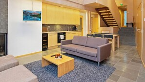 A modern interior with a sofa, coffee table, and kitchen area. - Villa sinikka 2 by Interhome (Mikkeli)