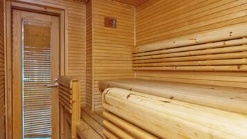 Ein Saunaraum mit Holzbänken und einer Tür mit Jalousien.