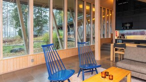 Un intérieur moderne avec de grandes fenêtres, un plafond en bois et un coin cuisine.