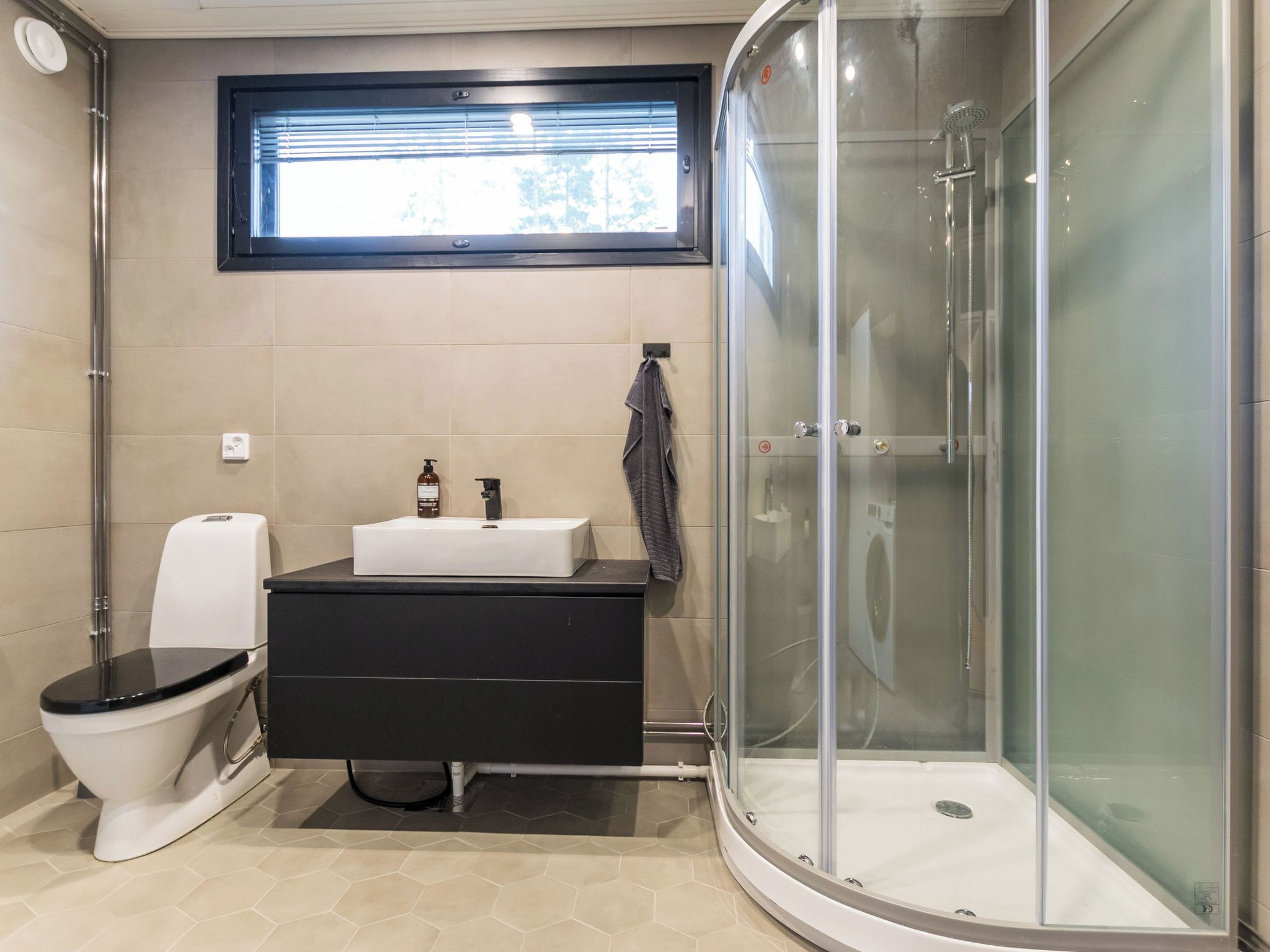 Een badkamer met toilet, wastafel en douche.