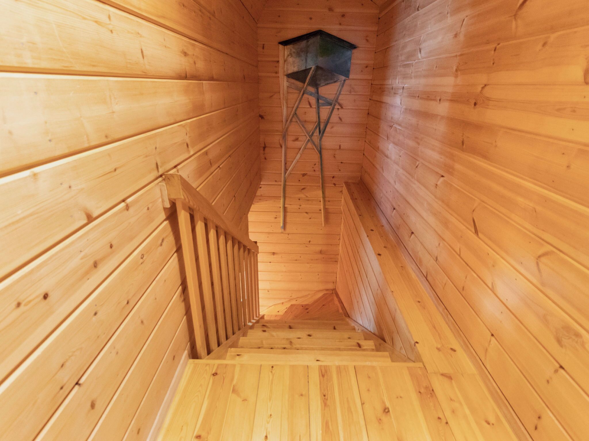 A wooden staircase with a metal ladder and a wooden railing.