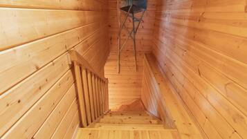 A wooden staircase with a metal ladder and a wooden railing.