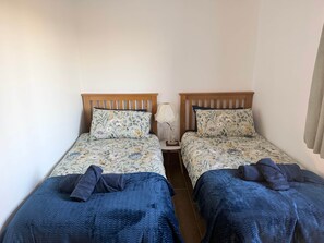 A twin room with two beds, each with floral bedding and wooden headboards.