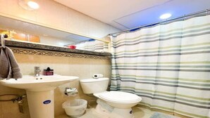A bathroom with a sink, toilet, and striped shower curtain.