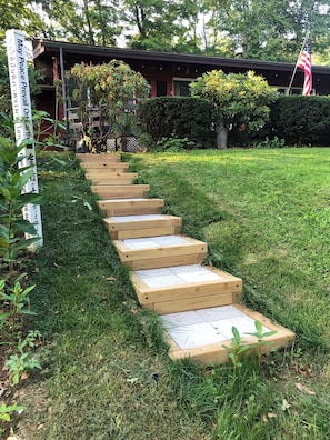 A wooden staircase leading up to a building with a sign that reads 'May Peace Prevail.'