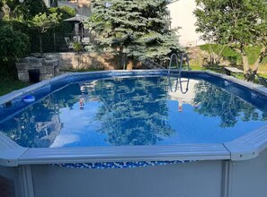 A swimming pool with a clear view of the surrounding landscape, including trees and a stone wall. - Istrian Private Garden Oasis (Zminj)