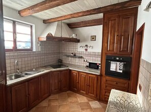 A kitchen with wooden cabinets, a tiled backsplash, a built-in oven, and a window.