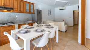 A modern kitchen with granite countertops, wooden cabinets, a built-in stove, and a stainless steel refrigerator. - A.m. Apartments (Vrsar)