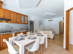 Eine moderne Küche mit Holzausstattung, einem eingebauten Herd und einem Kühlschrank.