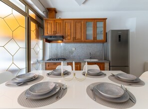 Eine moderne Küche mit Granit-Arbeitsplatten, Holzschränken und einem Edelstahl-Kühlschrank.