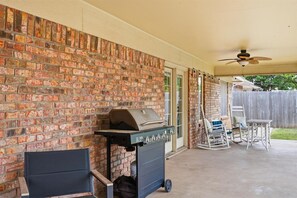 An outdoor patio with a brick wall, a grill, a ceiling fan, and outdoor furniture. - Long Live Cowboys!  3-Bed 2-Bath Near ACU and Expo (Abilene)