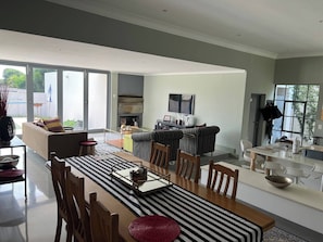 Un amplio espacio habitable con una mesa de comedor, sofás y televisor.