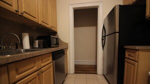 A kitchen with wooden cabinets, a stainless steel refrigerator, a dishwasher, and a microwave.