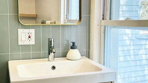 A bathroom with a white sink, a mirror, and a window. - The Quaint House: Modern Heritage in Roundout Kingston Waterfront (Kingston)