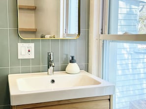 A bathroom with a white sink, a mirror, and a window. - The Quaint House: Modern Heritage in Roundout Kingston Waterfront (Kingston)