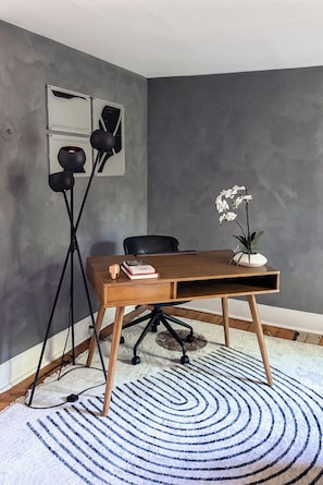 A corner room with a desk, chair, floor lamp, and a potted orchid. - The Quaint House: Modern Heritage in Roundout Kingston Waterfront (Kingston)