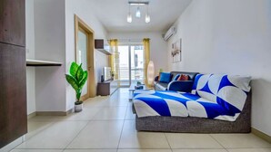 Ein modernes Wohnzimmer mit einer Couch, einem Blumentopf und Blick durch eine Glastür.