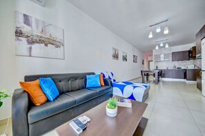 Un saló modern amb un sofà, una taula de centre i una obra d'art a la paret.