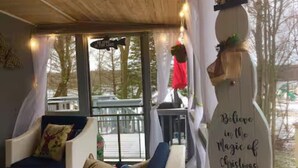 A cozy room with a sofa, a decorative wall sign, and a view through a window. - Beach by the Lake -Cozy Stay with Gorgeous Views (Pocono lake)