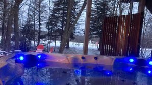 A hot tub with blue lights, surrounded by trees and a wooden fence. - Beach by the Lake -Cozy Stay with Gorgeous Views (Pocono lake)