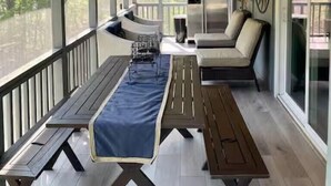 A covered outdoor area with a wooden ceiling, a dining table, a sofa, and a large window. - Beach by the Lake -Cozy Stay with Gorgeous Views (Pocono lake)