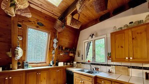 A kitchen with wooden cabinets, a sink, and a window. - Rustic Pine Lodge - Cozy 4 BR Adirondack Escape (Schroon Lake)