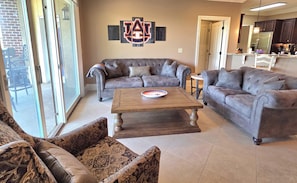 A living room with a grey sectional sofa, a coffee table, and patterned armchairs.