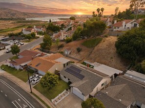 A residential area with houses, a road, and a sunset in the background. - 5BR Hot Tub Retreat | Sleeps 14 & BBQ (Spring Valley)