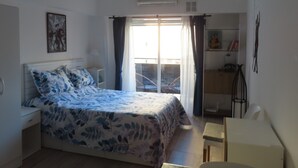 Een slaapkamer met een bed, een bureau en een stoel.
