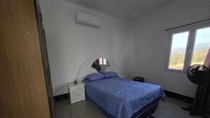 Una camera da letto con un letto, un comodino, una lampada e una finestra.