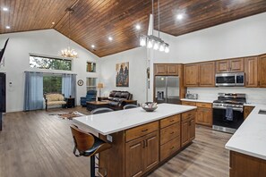 A spacious kitchen with wooden cabinets, a large island, and modern appliances. - NEW 3-bedroom 2-bath house in marvelous Lake of the Woods with central AC (Lake of the Woods)