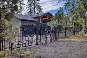 A gated property with a building that has a sloped roof and a garage. - NEW 3-bedroom 2-bath house in marvelous Lake of the Woods with central AC (Lake of the Woods)