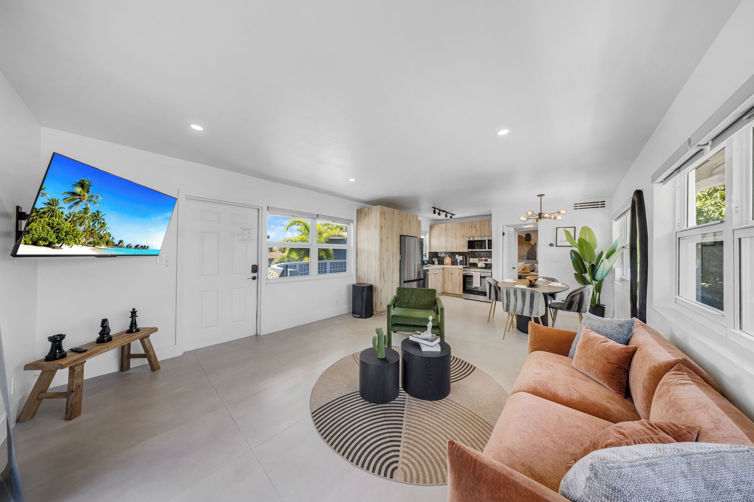 A modern living room with a sofa, coffee table, and a TV mounted on the wall.