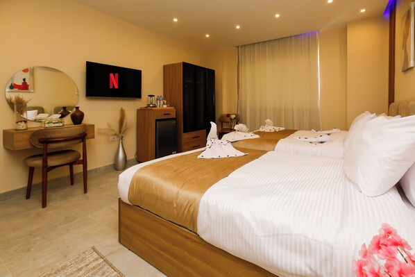 Una habitación de hotel con una cama, un escritorio, un televisor y un mini bar.