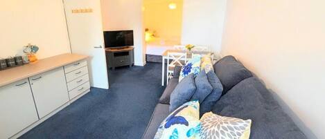 Suite estudio superior, vista al patio | Área de sala de estar