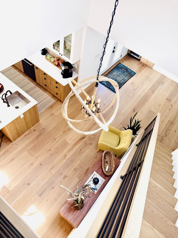 A modern interior with a kitchen, dining area, and a staircase.