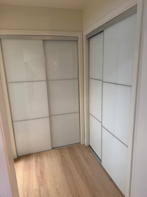 Ein Zimmer mit einer Schiebetür, Holzboden und einer weißen Wand.