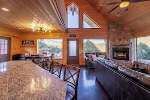 A wooden interior with a stone fireplace, a bar area, and a dining space.