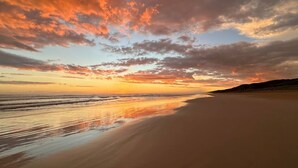 A beach with a sunset, calm sea, and a clear sky. - The Deck @ VB - Linen, Wi-Fi, Pets, Secured Yard (Venus Bay)