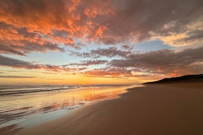 A beach with a sunset, calm sea, and a clear sky. - The Deck @ VB - Linen, Wi-Fi, Pets, Secured Yard (Venus Bay)