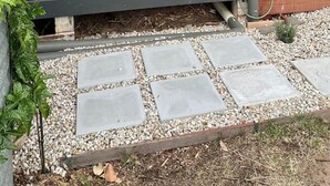 A grey exterior wall with a metal water spigot and a wooden plank. - The Deck @ VB - Linen, Wi-Fi, Pets, Secured Yard (Venus Bay)