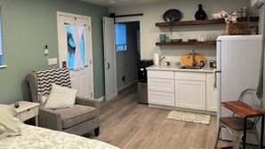 Un espacio habitable compacto con kitchenette, comedor y dormitorio.