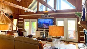 Un intérieur en bois avec une télévision, un canapé en cuir et une pancarte portant l’inscription « Magnifique ».